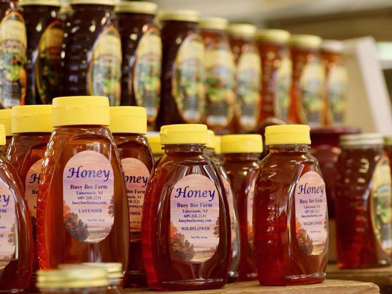 Rows of local honey from Busy Bee Farm on a shelf at Red Top Farm Market