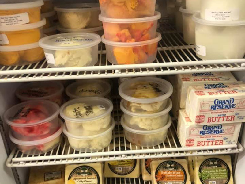 An open fridge with local farm cheese and butter for sale