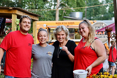 A group of people standing together and smiling outside of Red Top Farm Market.